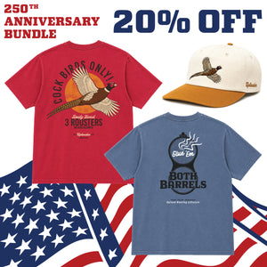 250th Anniversary Bundle — 20% off 'Cock Birds Only' red t-shirt, 'Give 'Em Both Barrels' blue t-shirt, and cream and gold unstructured hat with flying pheasant embroidery, displayed over an American flag background.