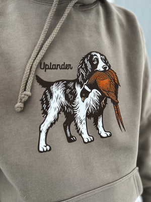 Right side view of a man wearing a grey hoodie featuring a graphic of an English Springer Spaniel holding a ring-necked pheasant in its mouth with Uplander branding.