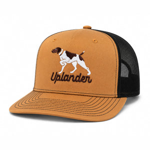 Caramel and black trucker hat with an embroidered liver and white German Shorthaired Pointer and 'Uplander' script in brown.