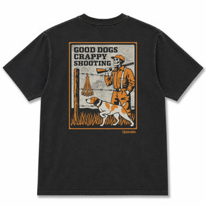 Back view of a black t-shirt featuring a vintage-style graphic of a skeleton hunter and bird dog with text 'Good Dogs Crappy Shooting' and Uplander branding.