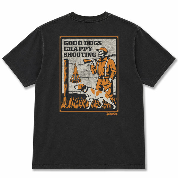 Back view of a black t-shirt featuring a vintage-style graphic of a skeleton hunter and bird dog with text 'Good Dogs Crappy Shooting' and Uplander branding.