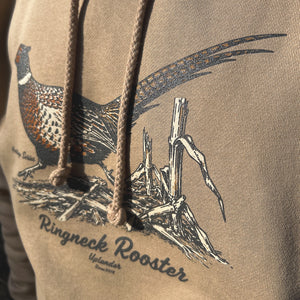 Detailed close-up of the rooster pheasant illustration and 'Ringneck Rooster' and 'Uplander' script on the tan heavyweight hoodie, showing the long tail feathers and cornfield detail.