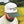Right-side view of a man wearing an ivory and dark green two-tone snapback hat with an embroidered sharptail grouse and 'Sharptail Grouse' script on the front, worn outdoors.