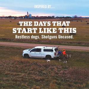 Hunter unloading bird dogs from a pickup truck at dawn in a harvested field with hay bales, with text 'The Days That Start Like This, Restless Dogs. Shotguns Uncased.'.