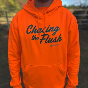 Man wearing a blaze orange heavyweight hoodie with 'Chasing the Flush' script graphic and 'Uplander' logo on the chest, with a kangaroo pocket and drawstring hood, worn outdoors.